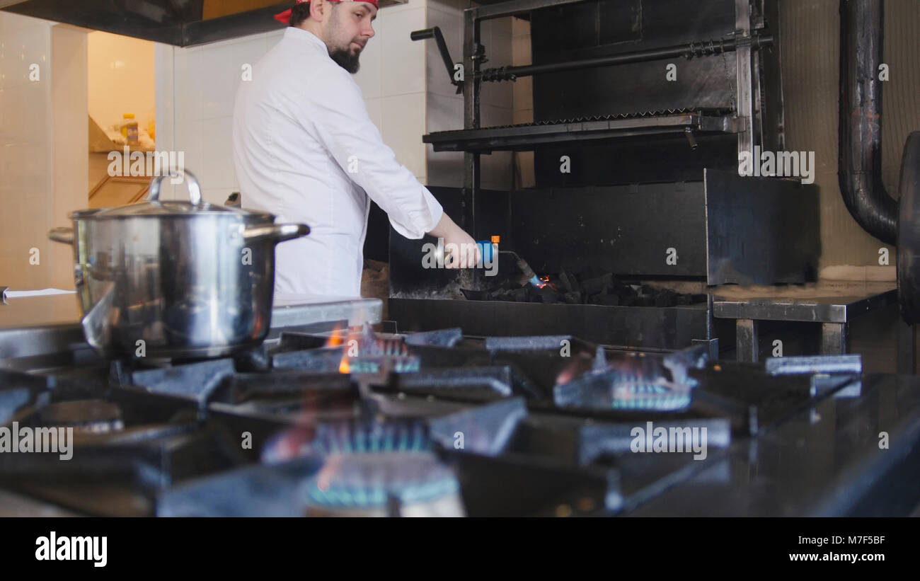 Kindling of charcoal in the barbecue oven using a gas burner slow