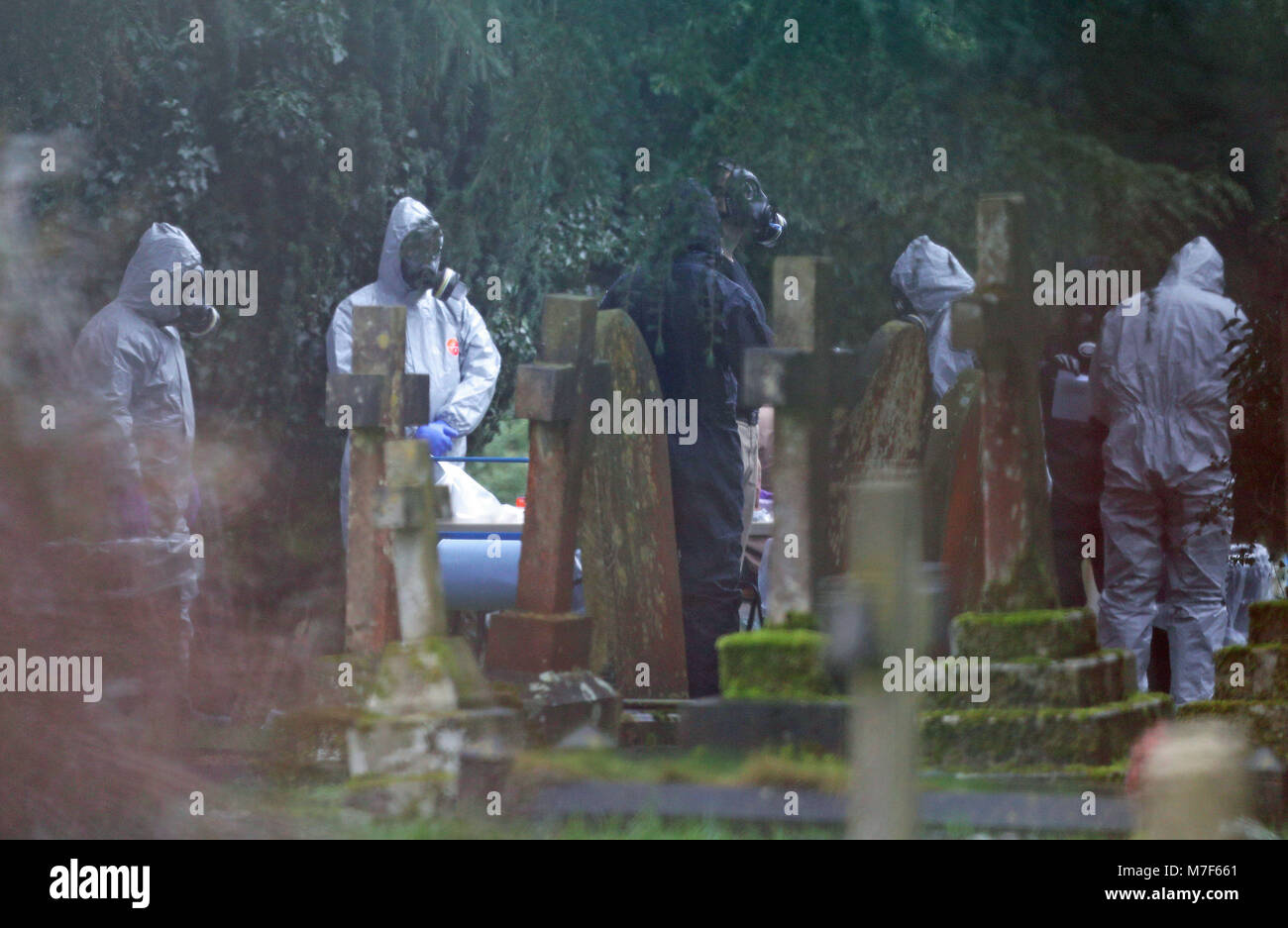 Forensic officers in gas masks at the London Road cemetery in Salisbury, Wiltshire, as investigations continue at the cemetery where former Russian double agent Sergei Skripal's wife and son were laid to rest. Stock Photo