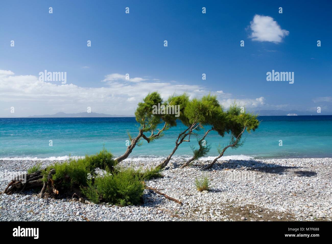 View of pebbly beach on western coast of Rhodes Island, Aegean Sea and Turkey coast in the background, Ialyssos, Greece Stock Photo