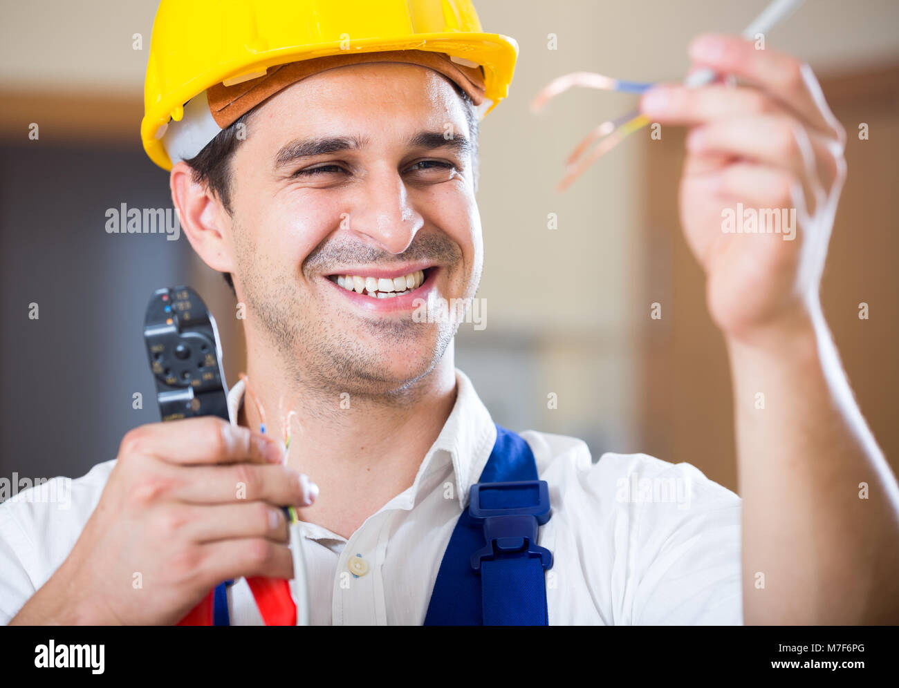 Professional electrician working with wires at client home Stock Photo