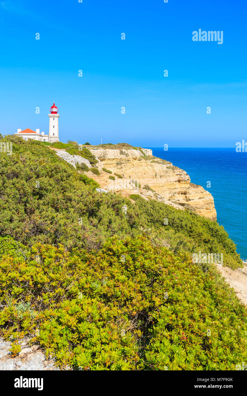 Lighthouse building on high cliff with sea in background near Carvoeiro town, Algarve, Portugal Stock Photo
