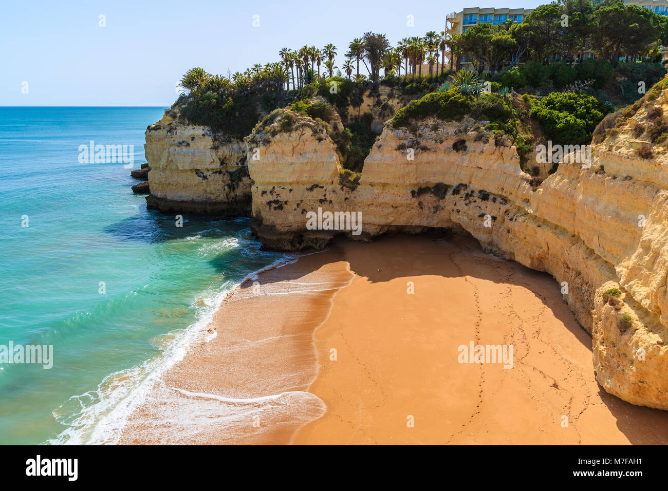 View of beach in small bay hotel building on high cliff in Armacao de Pera town, Algarve, Portugal Stock Photo