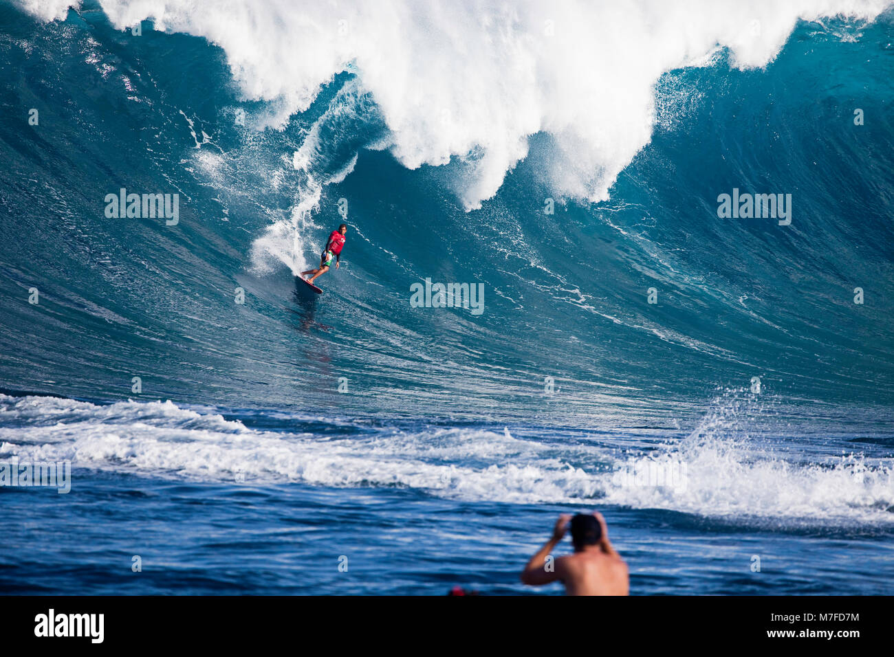 A tow-in surfer drops down the face of Hawaii's big surf at Peahi (Jaws) off Maui, Hawaii. Stock Photo