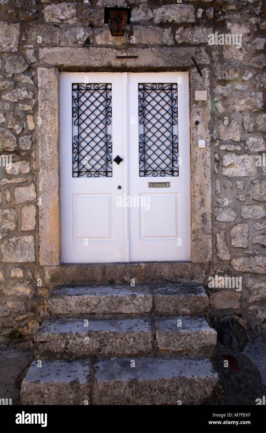 White Wooden Entrance Door With Black Wrought Iron Grills On