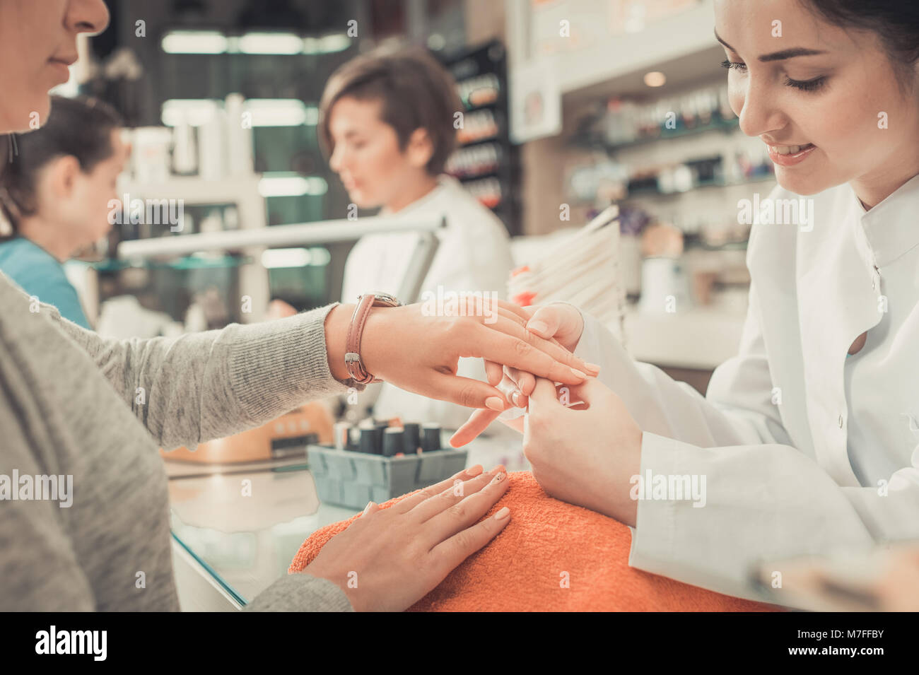 Nail masters performing manicure and massage in beauty salon Stock