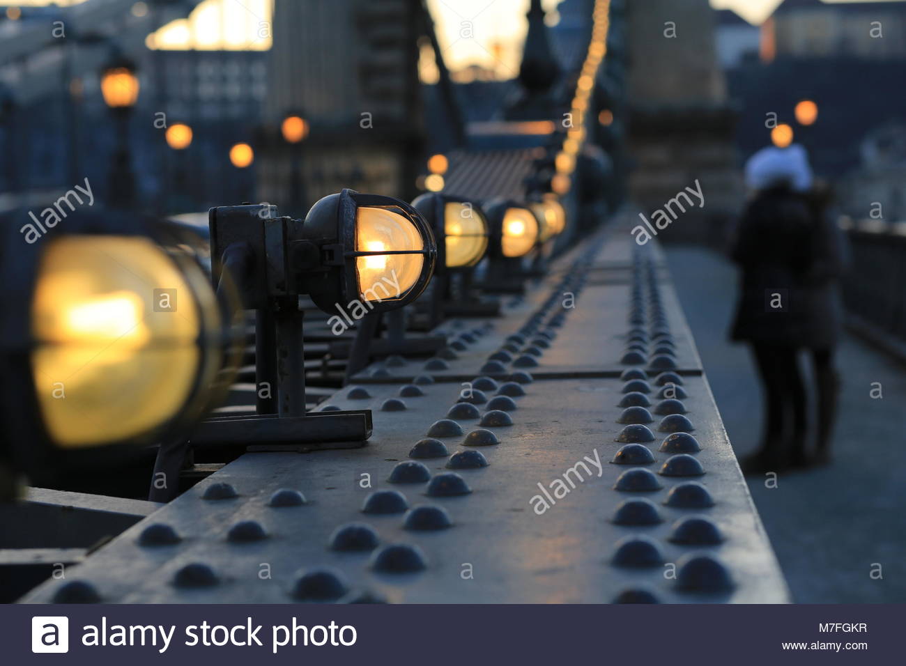 Lamps on a bridge in Budapest , Hungary, shine as dusks falls across the city. Stock Photo