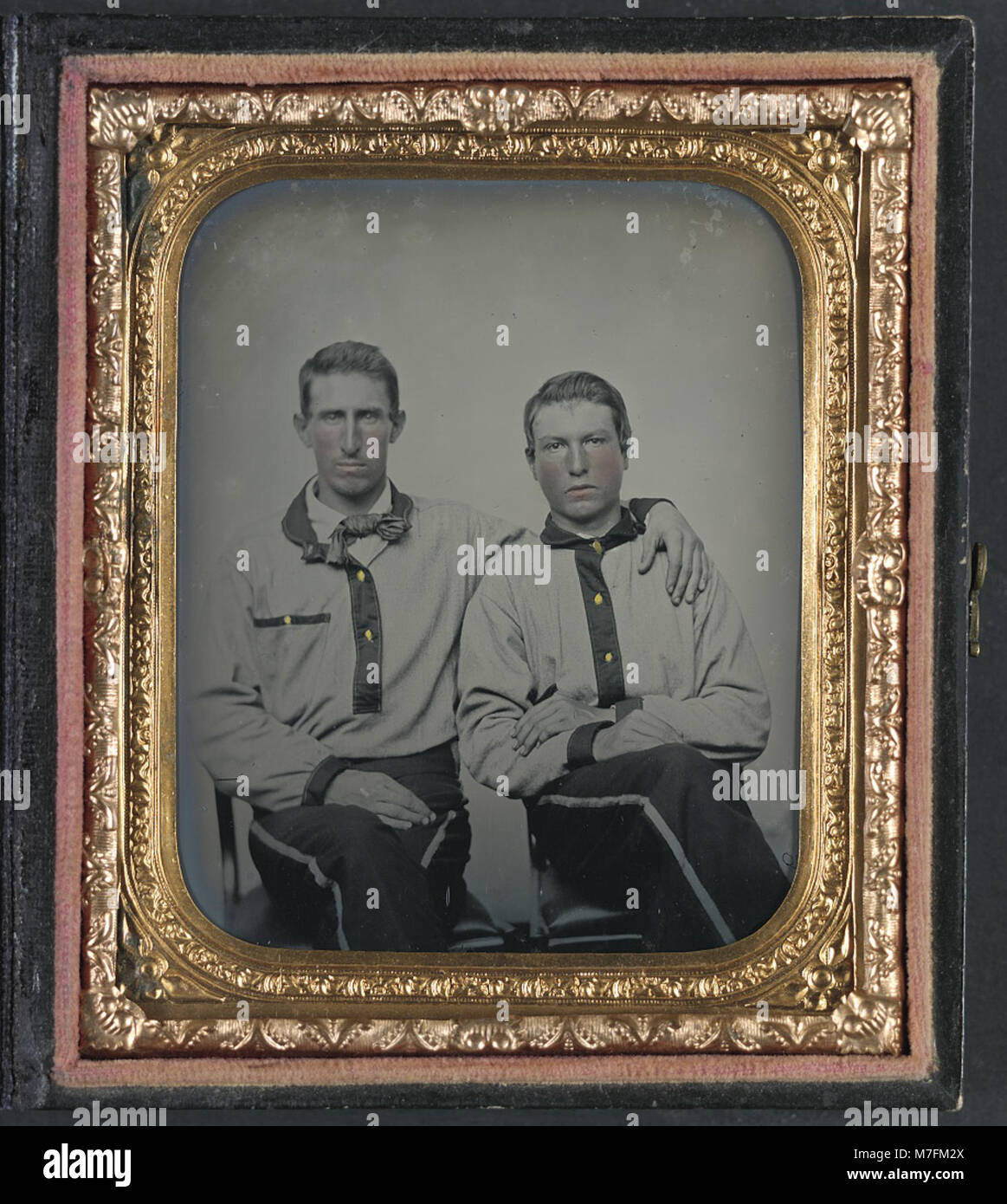 This image shows two unidentified soldiers wearing Confederate battle ...