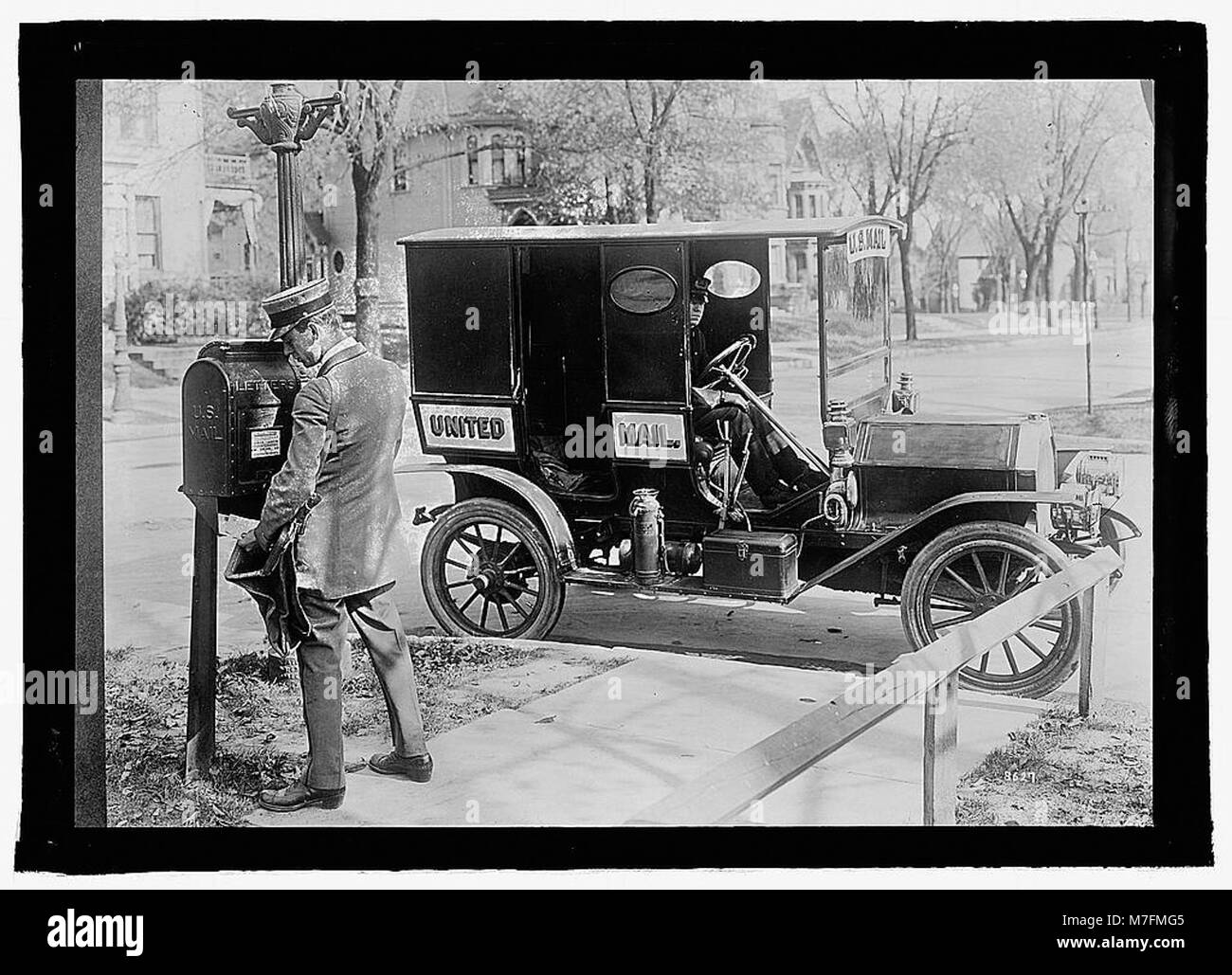 A U.S. mailman is seen delivering mail with a truck, showcasing early ...
