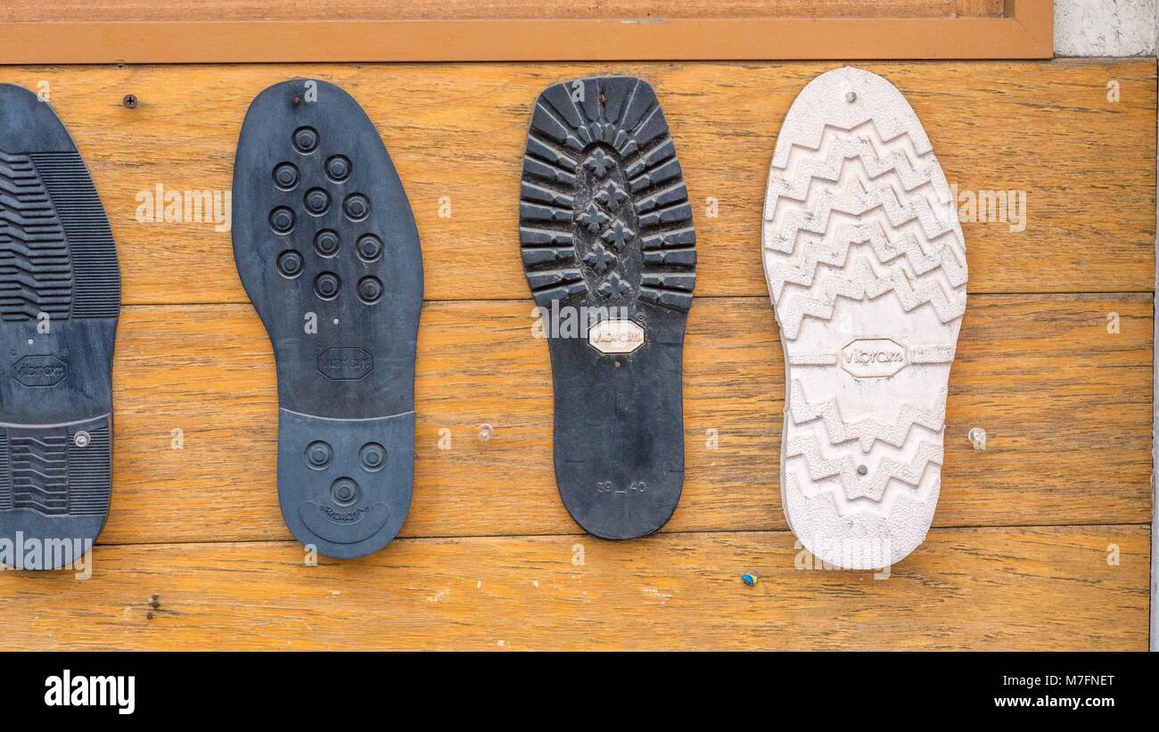Replacement white, black and blue boot soles nailed to the outside of a Japanese cobbler shop in Tokyo. Stock Photo