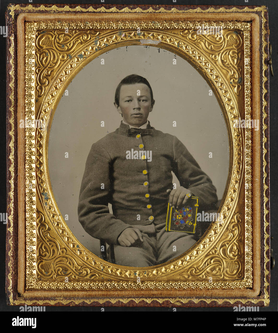 A photograph of an unidentified young soldier in a Confederate uniform ...