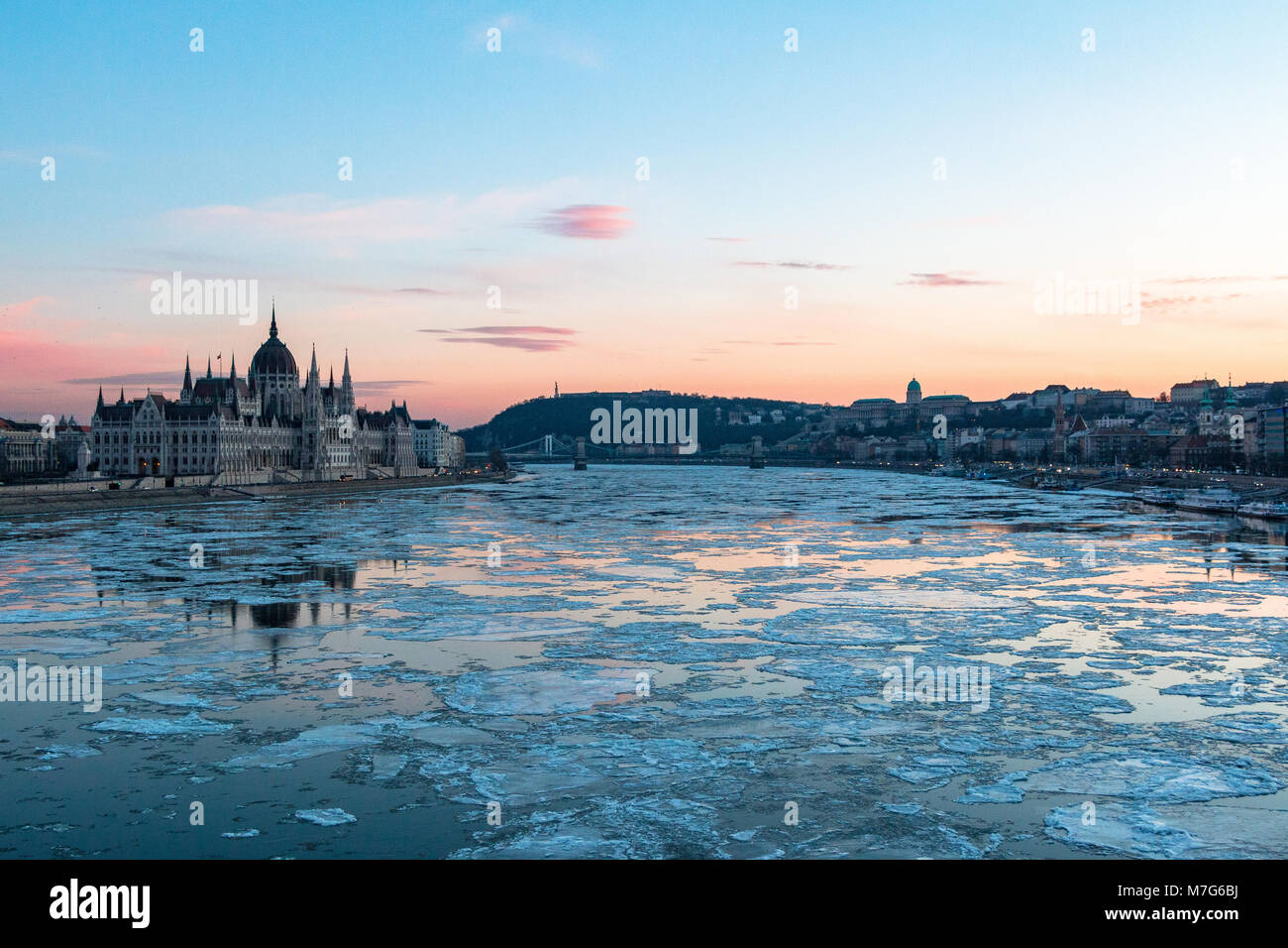 The Hungarian Parliament building and Royal Palace with ice floes on the Danube in Budapest in winter Stock Photo