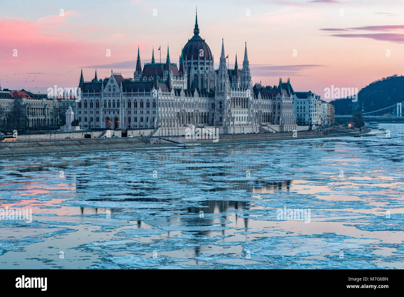 The Hungarian Parliament building with ice floes on the Danube in winter in Budapest, Hungary Stock Photo