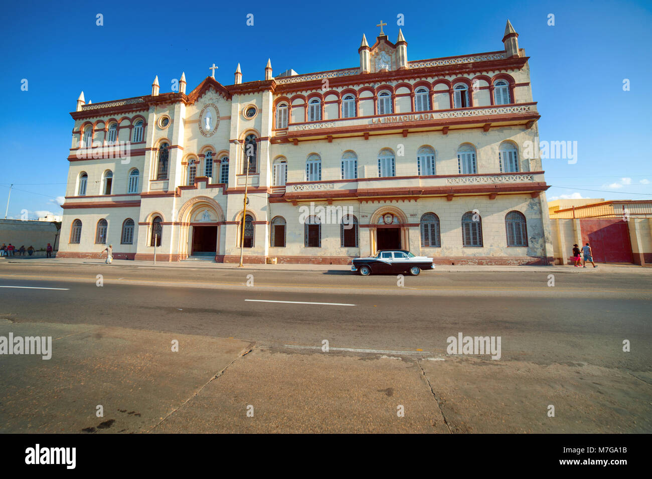 A classic car is parked outside La Inmaculada, a church and convent in Central Havana, Cuba Stock Photo