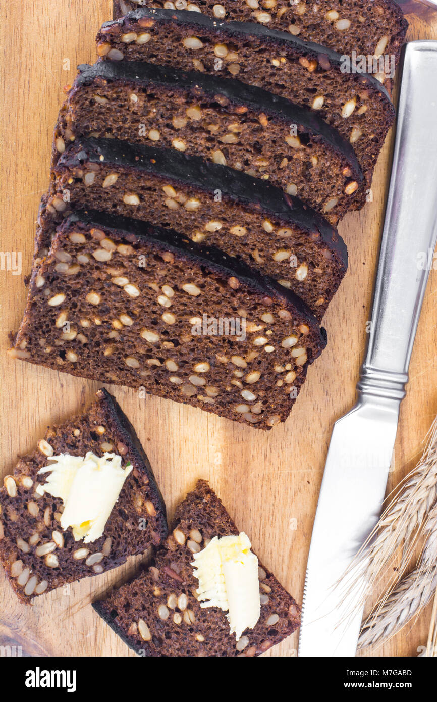 Sliced rye bread with sunflower seeds and butter Stock Photo