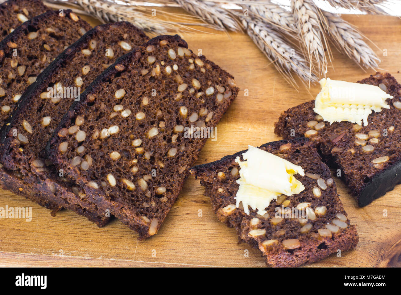 Sliced rye bread with sunflower seeds and butter Stock Photo