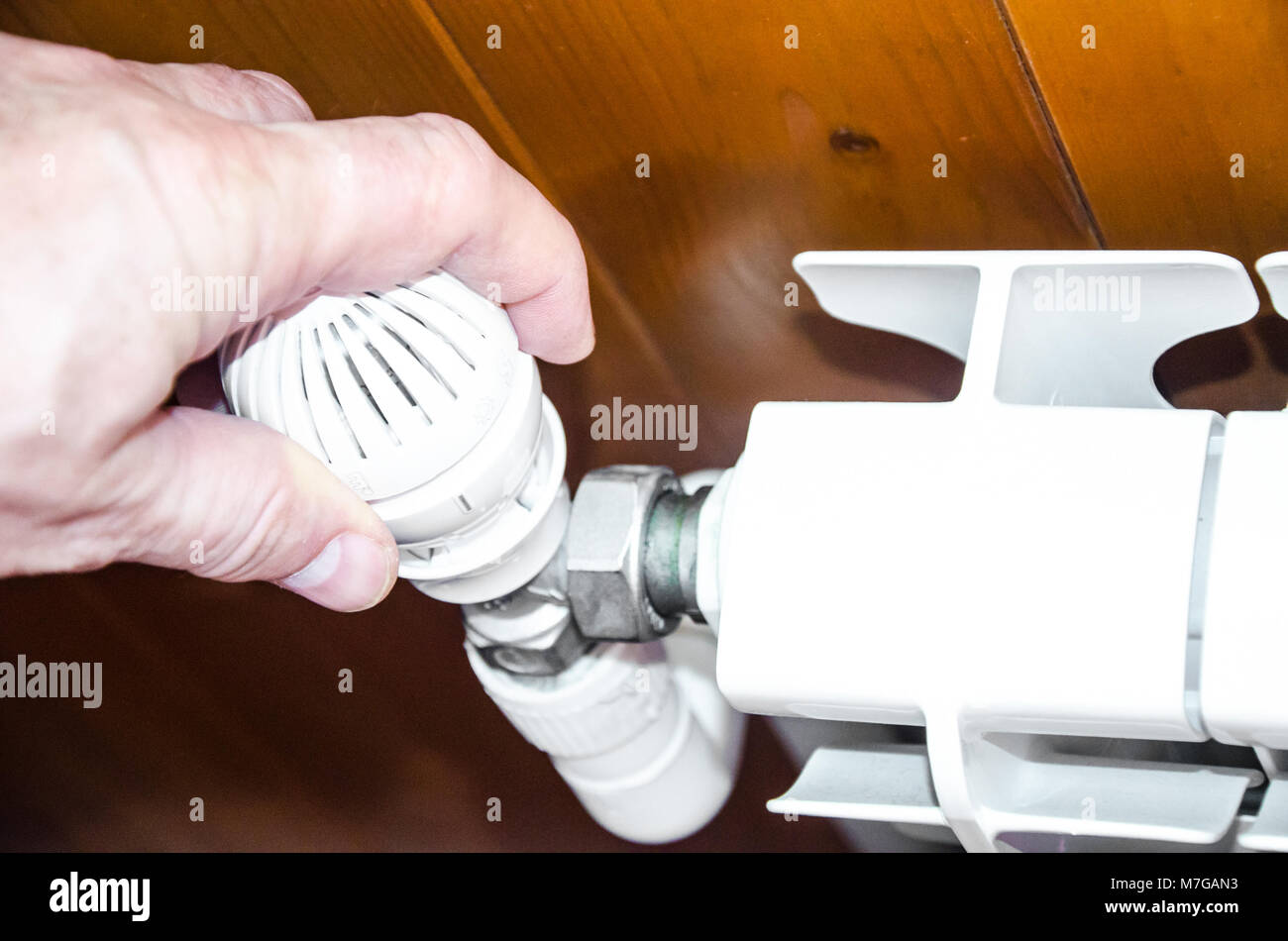 Hand regulates temperature in radiator Stock Photo - Alamy