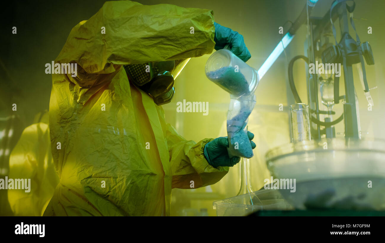 In the Underground Laboratory Clandestine Chemists in Protective Masks and Coveralls Cook and Package Drugs. They Work in the Abandoned Building. Stock Photo