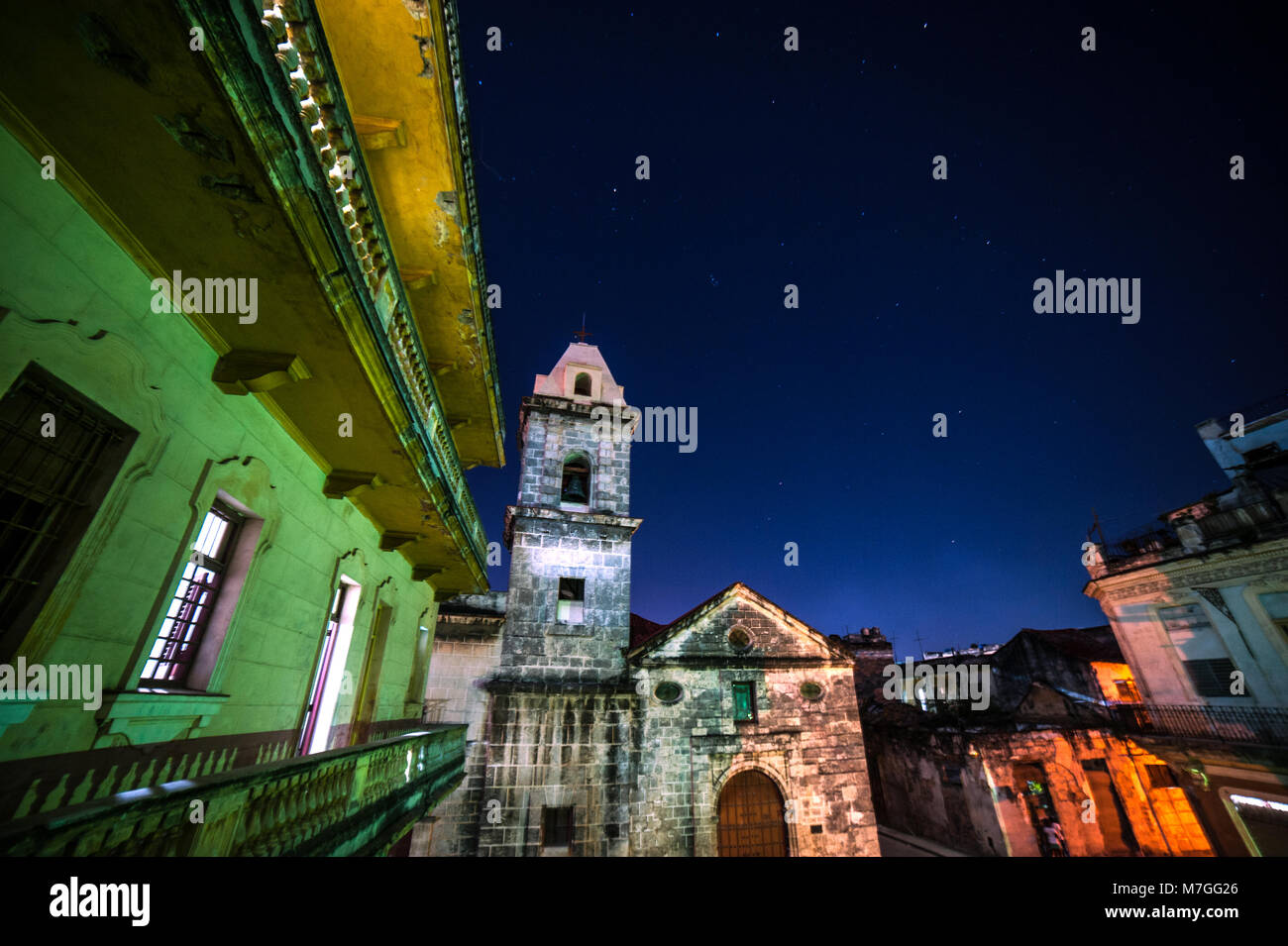 A 17th-century Spanish colonial church lit up under the night sky in Old Havana, Cuba Stock Photo