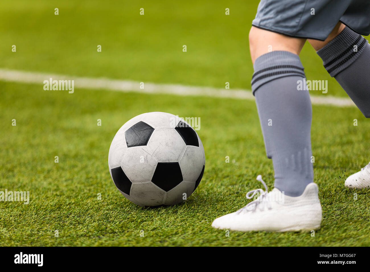 Football detail. Kicking the soccer ball. Football player feet and