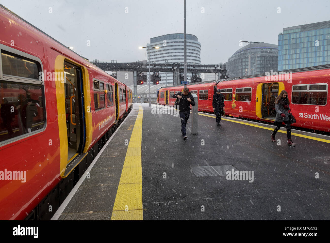 Passengers arriving at Waterloo station, London during a flurry of snow Stock Photo