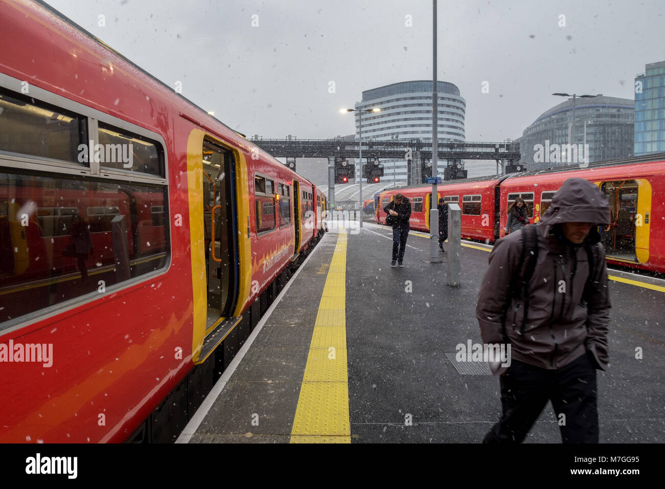 Passengers travelling to work, arriving at Waterloo station, London during a flurry of snow Stock Photo