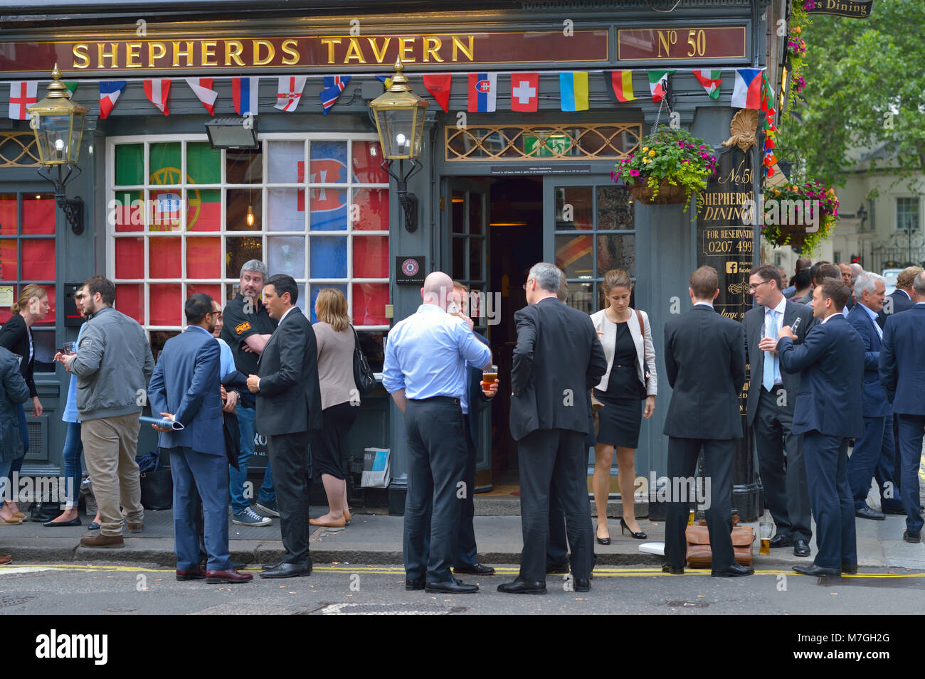 Formally dressed employees enjoying after work drinks at the Shepherds Tavern, London UK Stock Photo