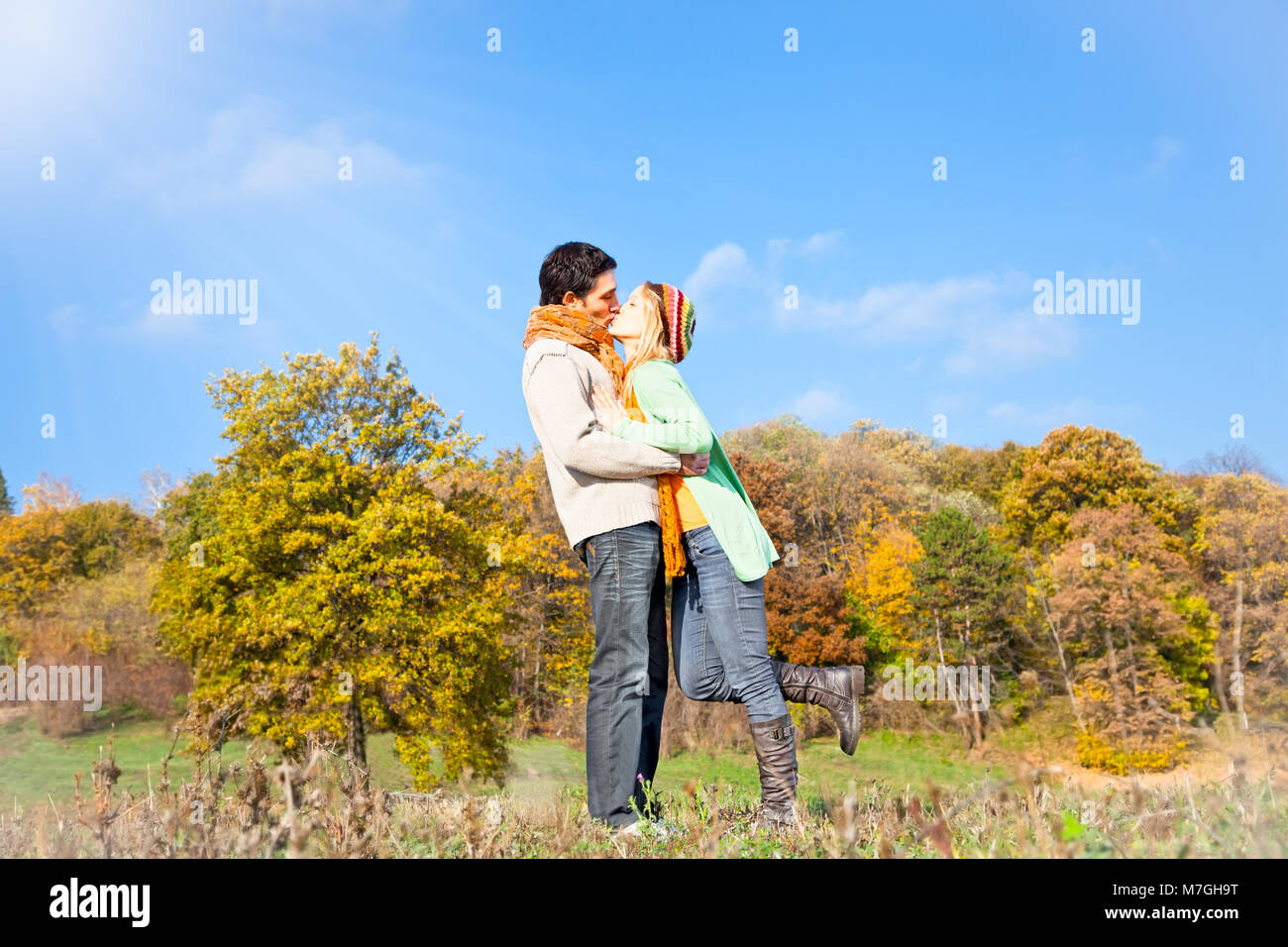 Young beautiful couple are kissing in the autumn park Stock Photo - Alamy