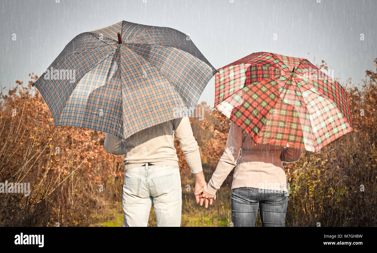 Young couple under an umbrella in the autumn forest Stock Photo - Alamy