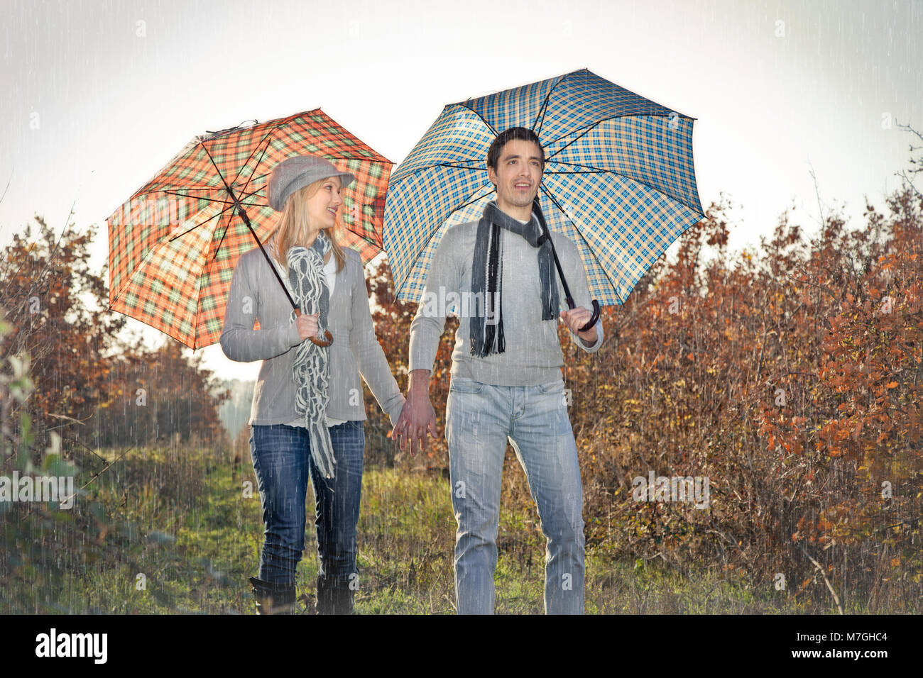Young couple under an umbrella on the autumn rain Stock Photo - Alamy