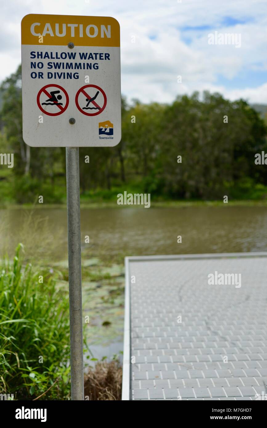 Caution shallow water no diving or swimming sign, Apex Park, Riverway Drive, Condon QLD