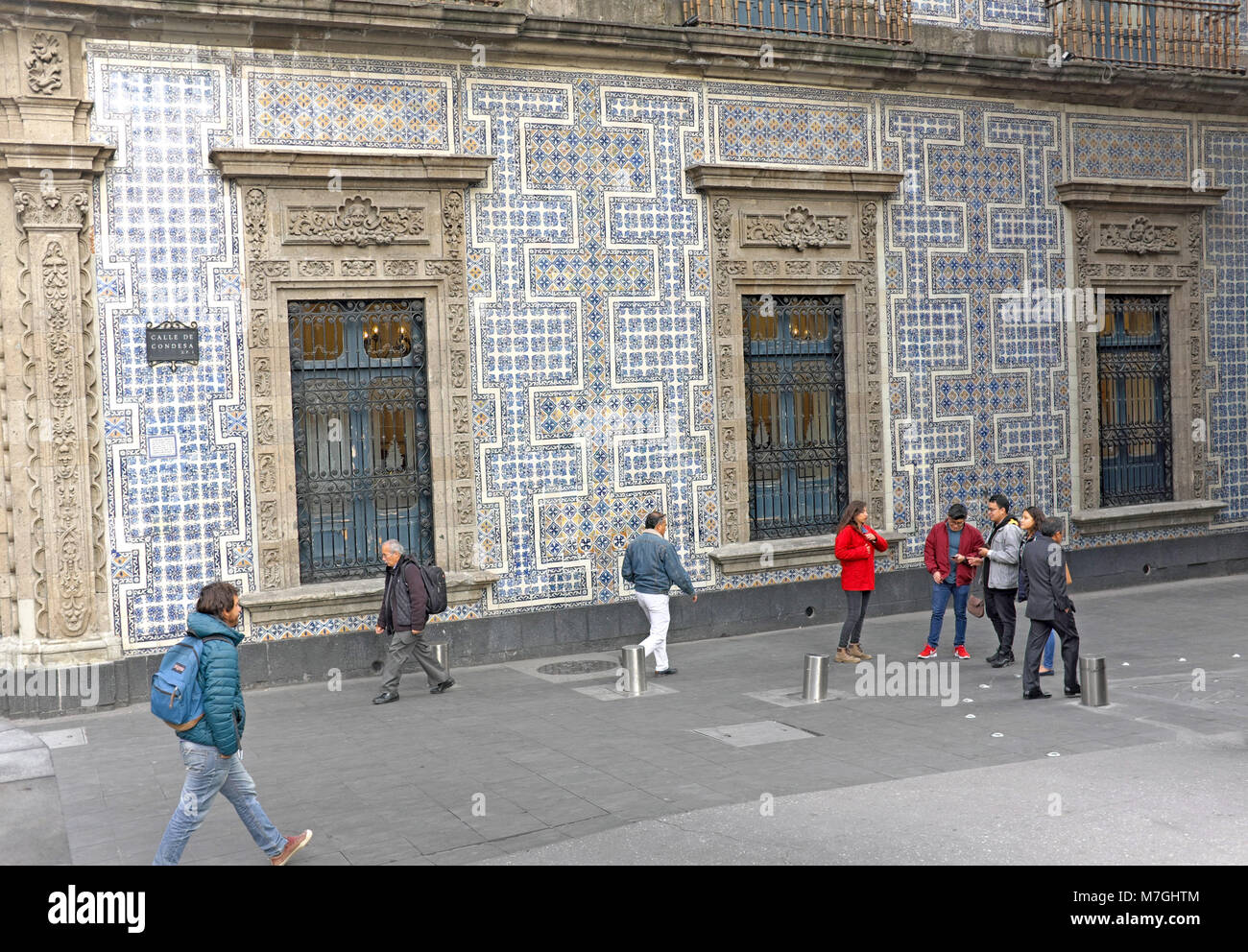 Pedestrians make their way along Calle de Consdesa next to the famous House of Blue Tiles in Mexico City, Mexico. Stock Photo