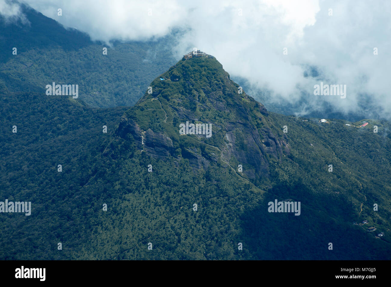 Adam's Peak, is a 2,243 m tall conical mountain located in central Sri Lanka. It is well known for the Sri Pada, or 'sacred footprint', which is belie Stock Photo