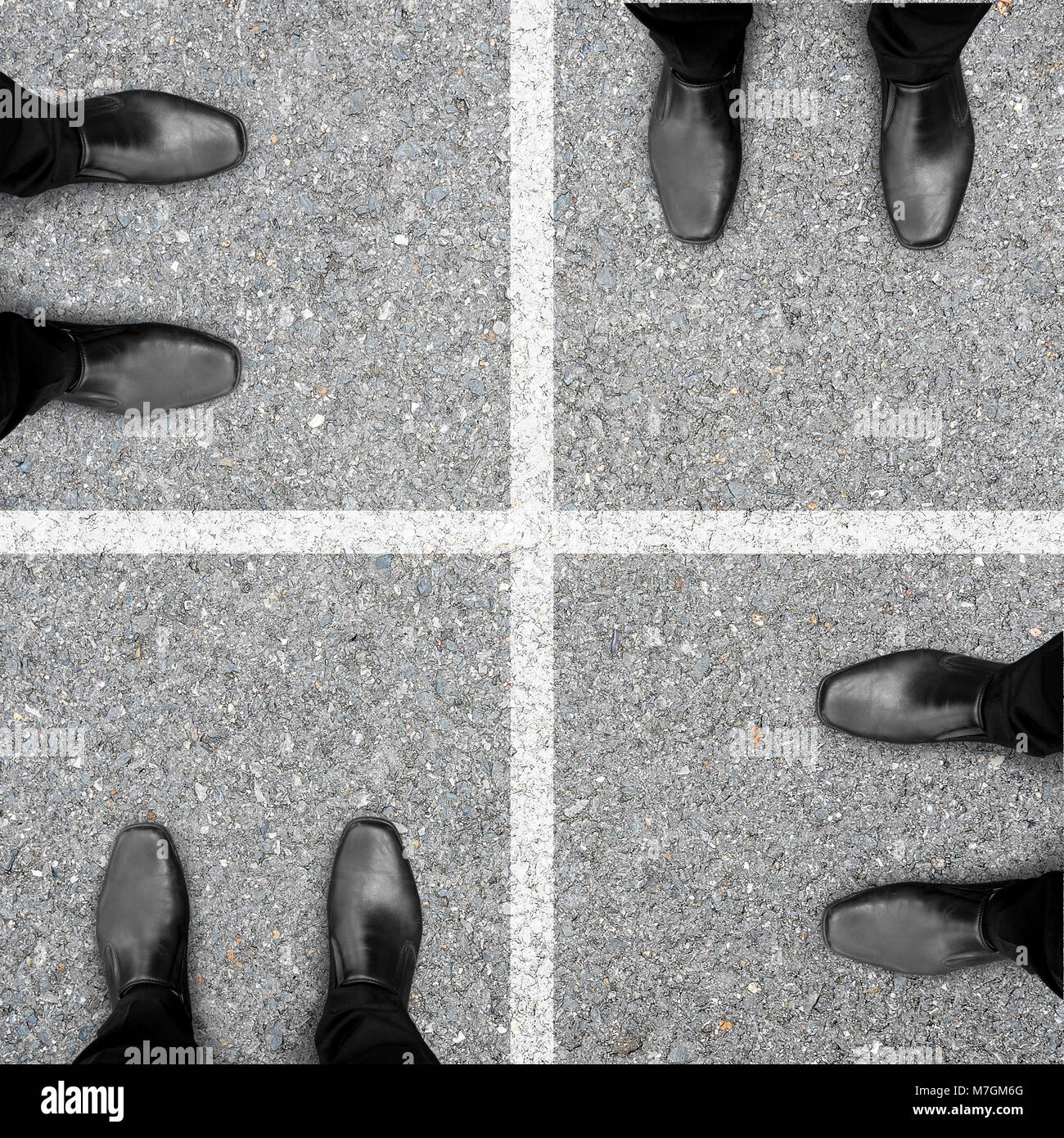 Four businessmen in black shoes standing in square frame turn to next one clockwise. Representing four steps of business success. Stock Photo