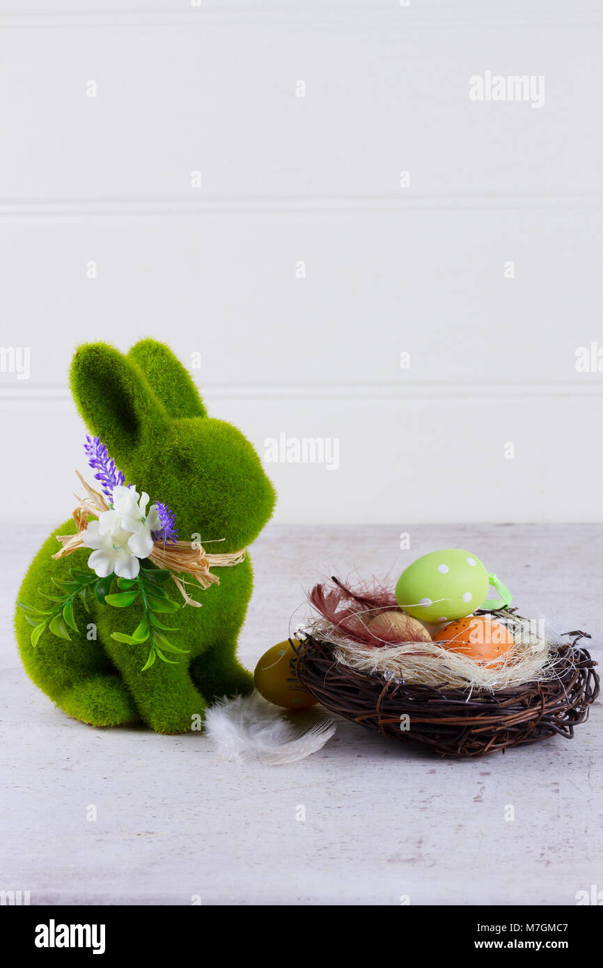 Easter scene with colored eggs in nest and green bunny Stock Photo - Alamy