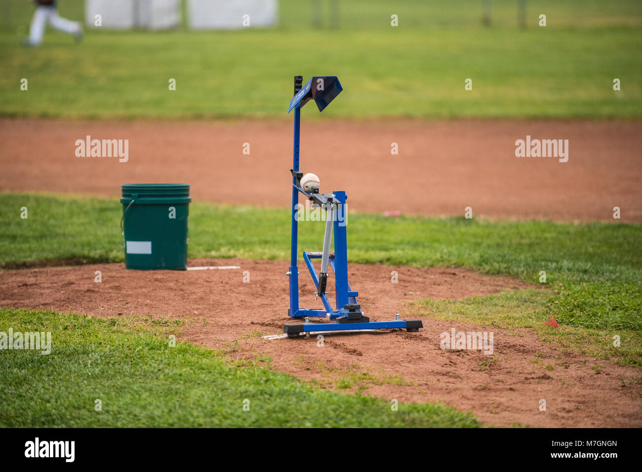 Youth baseball mechanical pitching machine set up on the infield mound to practice batting. Stock Photo