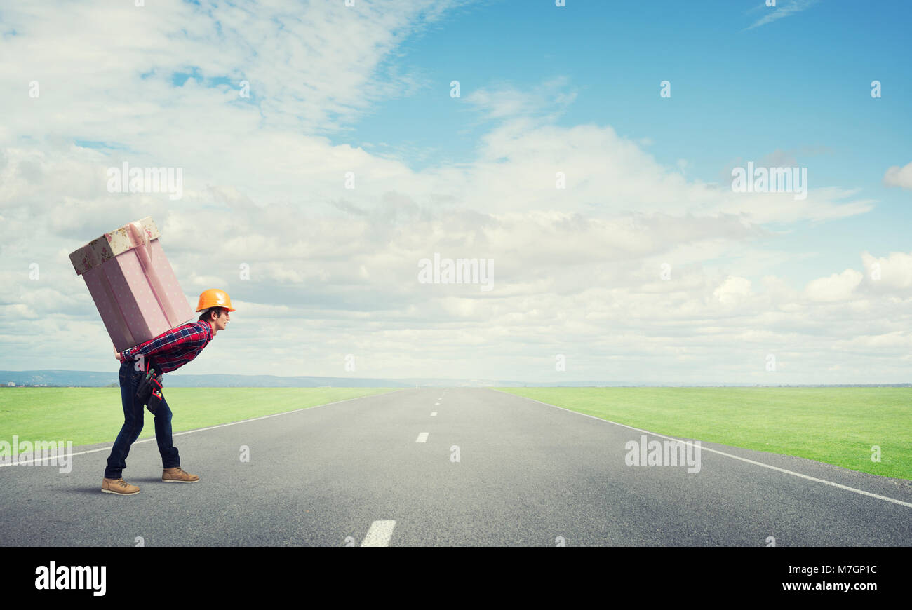 Man carrying on his back large box Stock Photo - Alamy