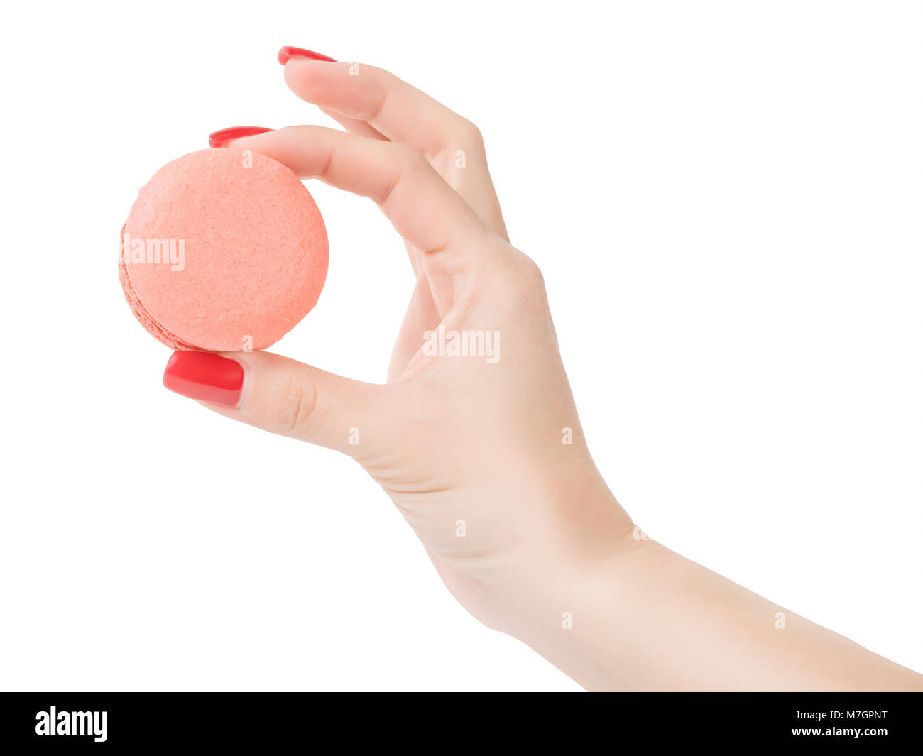 Woman hand holding pink round macaroon. Isolated on white, clipping path included Stock Photo