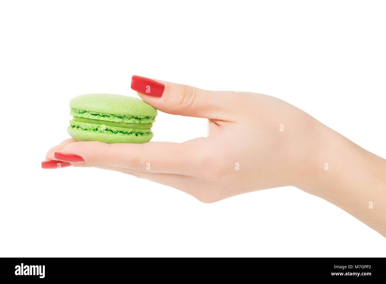 Woman hand holding or giving green round macaroon. Isolated on white, clipping path included Stock Photo