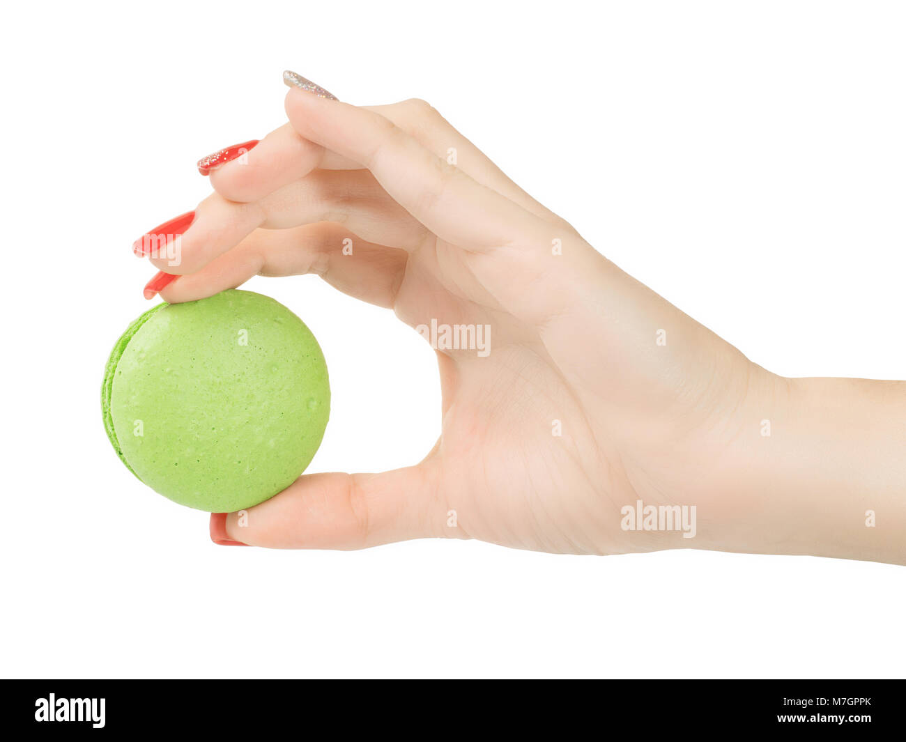 Woman hand holding green round macaroon. Isolated on white, clipping path included Stock Photo