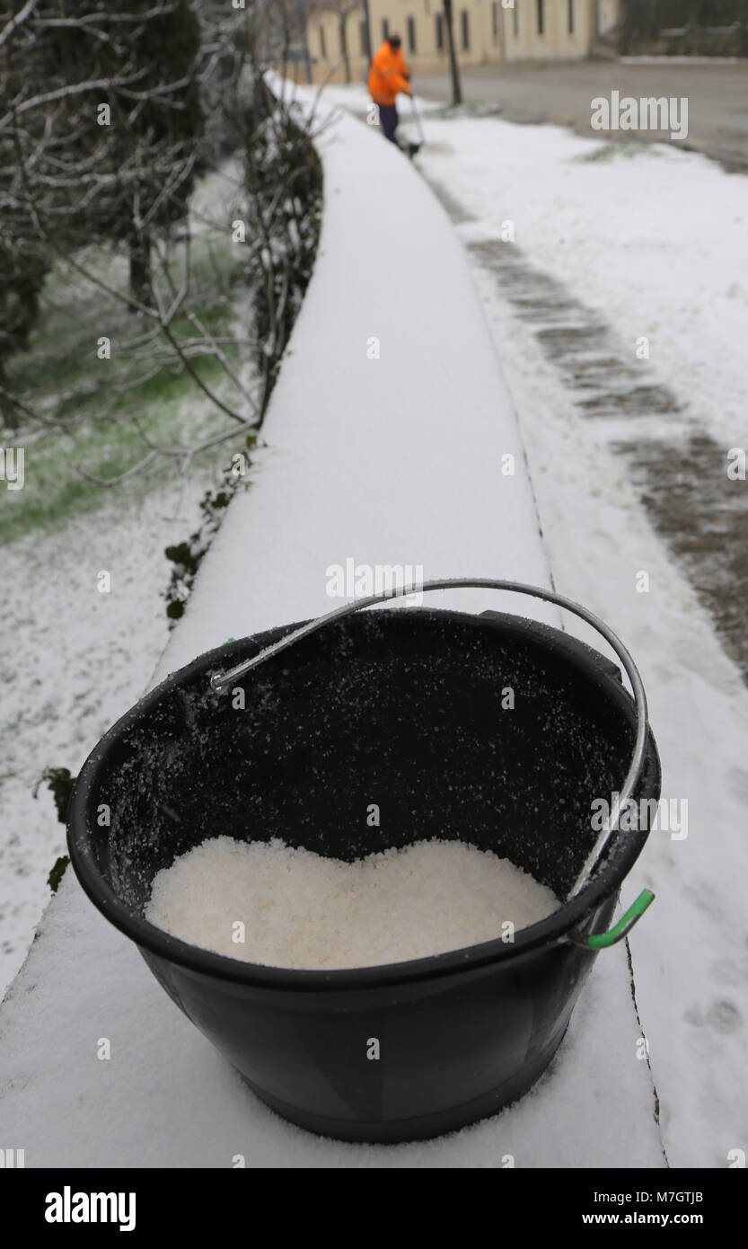 bucket with salt to melt ice from the sidewalk and the ecological