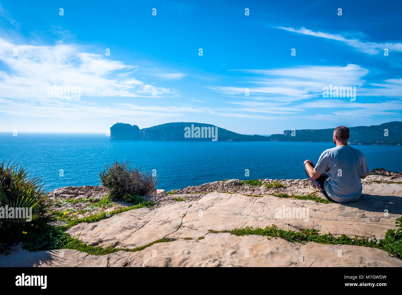 Man sitting looking at the sea Stock Photo - Alamy