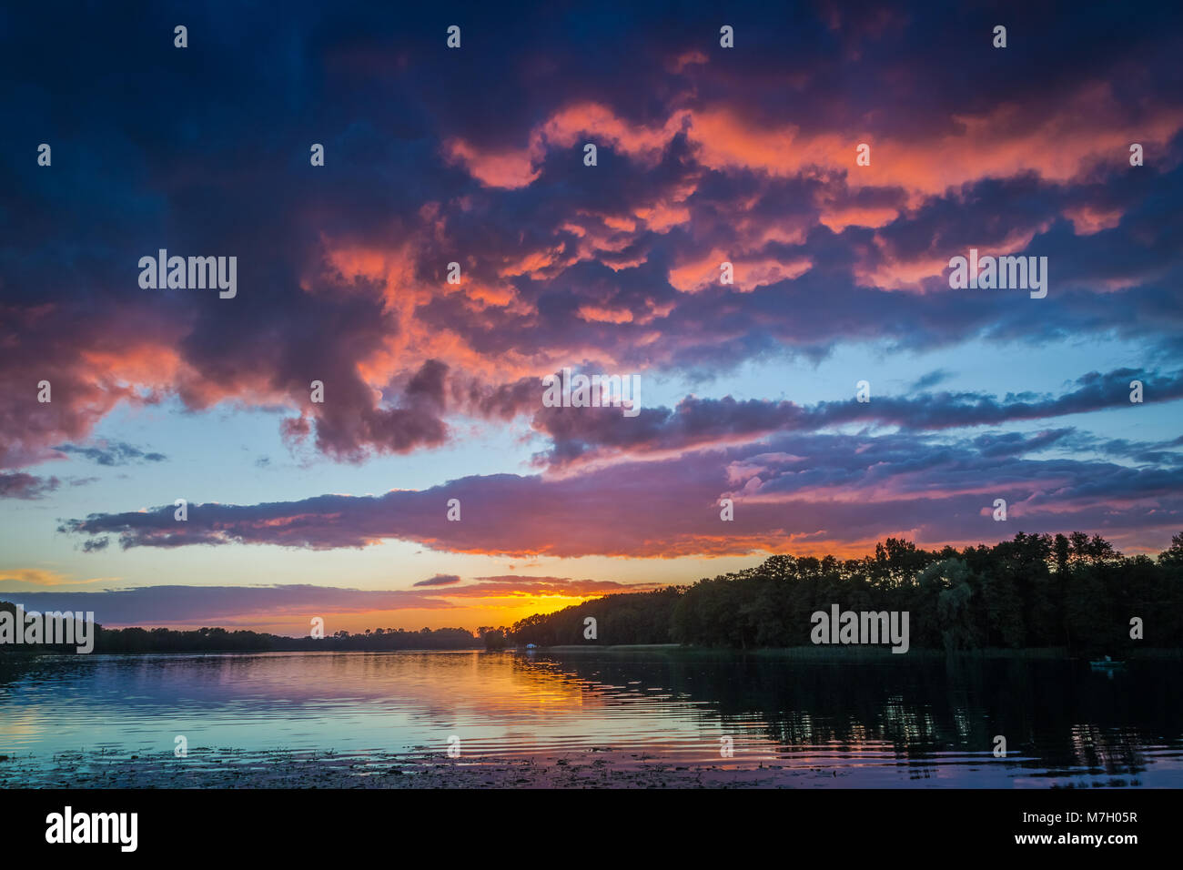 Stunning dusk with dynamic sky at the lake Stock Photo - Alamy