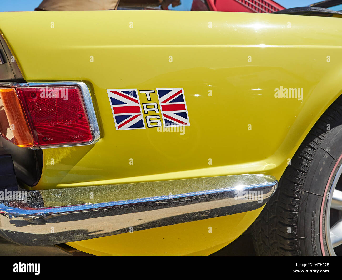 Right rear wing or quarter panel of 1985 British sports car Triumph TR6, painted yellow with Union Jack decal and logo. Stock Photo