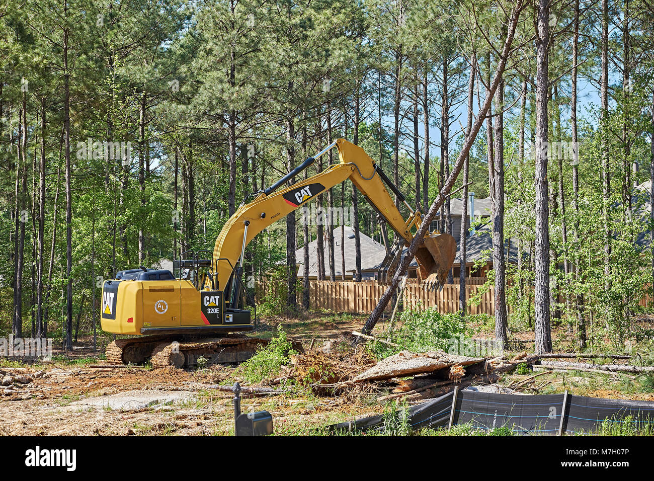 Digger or excavator clearing land for new construction building lot in Pike Road Alabama, USA. Stock Photo