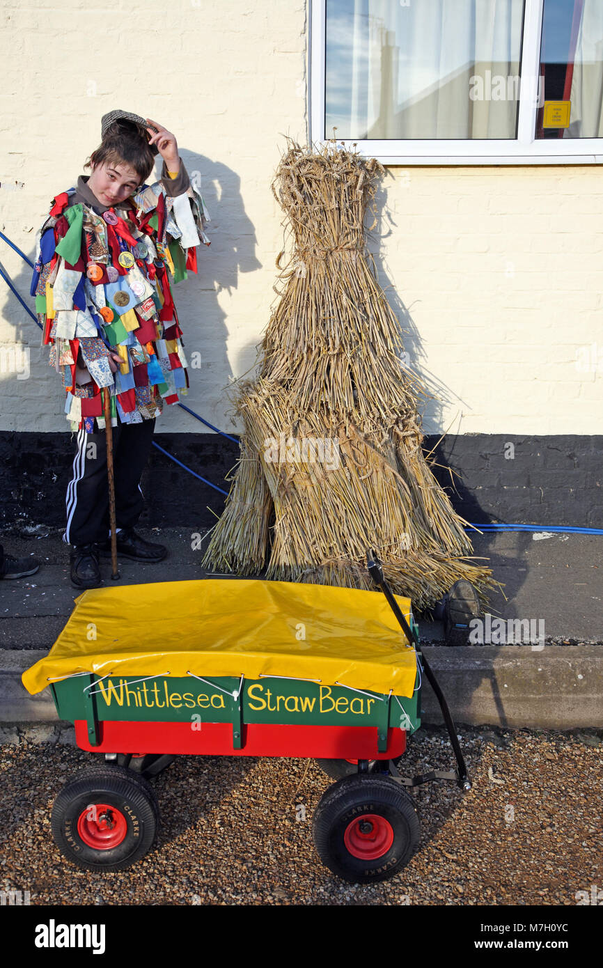 A young Morris boy stands guard over a straw bear at the annual Whittlesey Straw Bear Festival, Cambridgeshire. Stock Photo