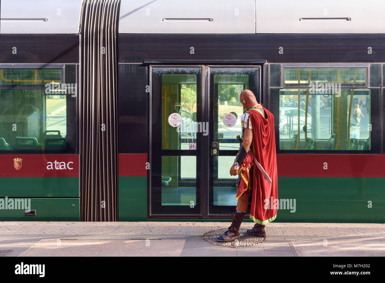 Costumed Roman Gladiator waiting for ATAC tram, Rome, Italy Stock Photo