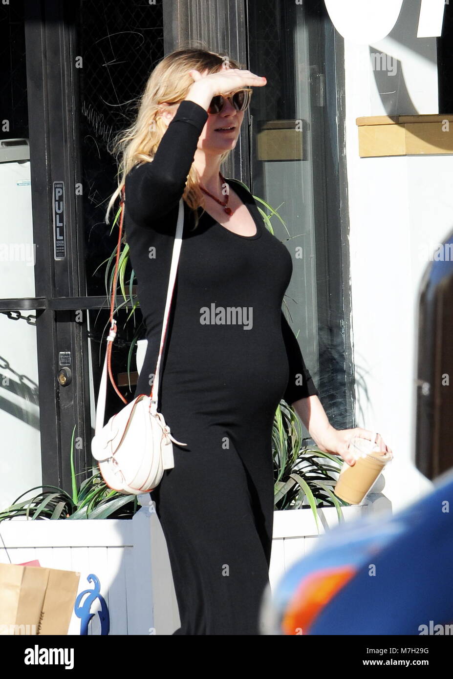 Pregnant Kirsten Dunst shows off her growing baby bump in a tight
