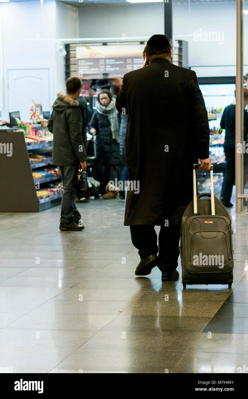 Hasid airport. Jew orthodox with a suitcase is going around the airport. Stock Photo