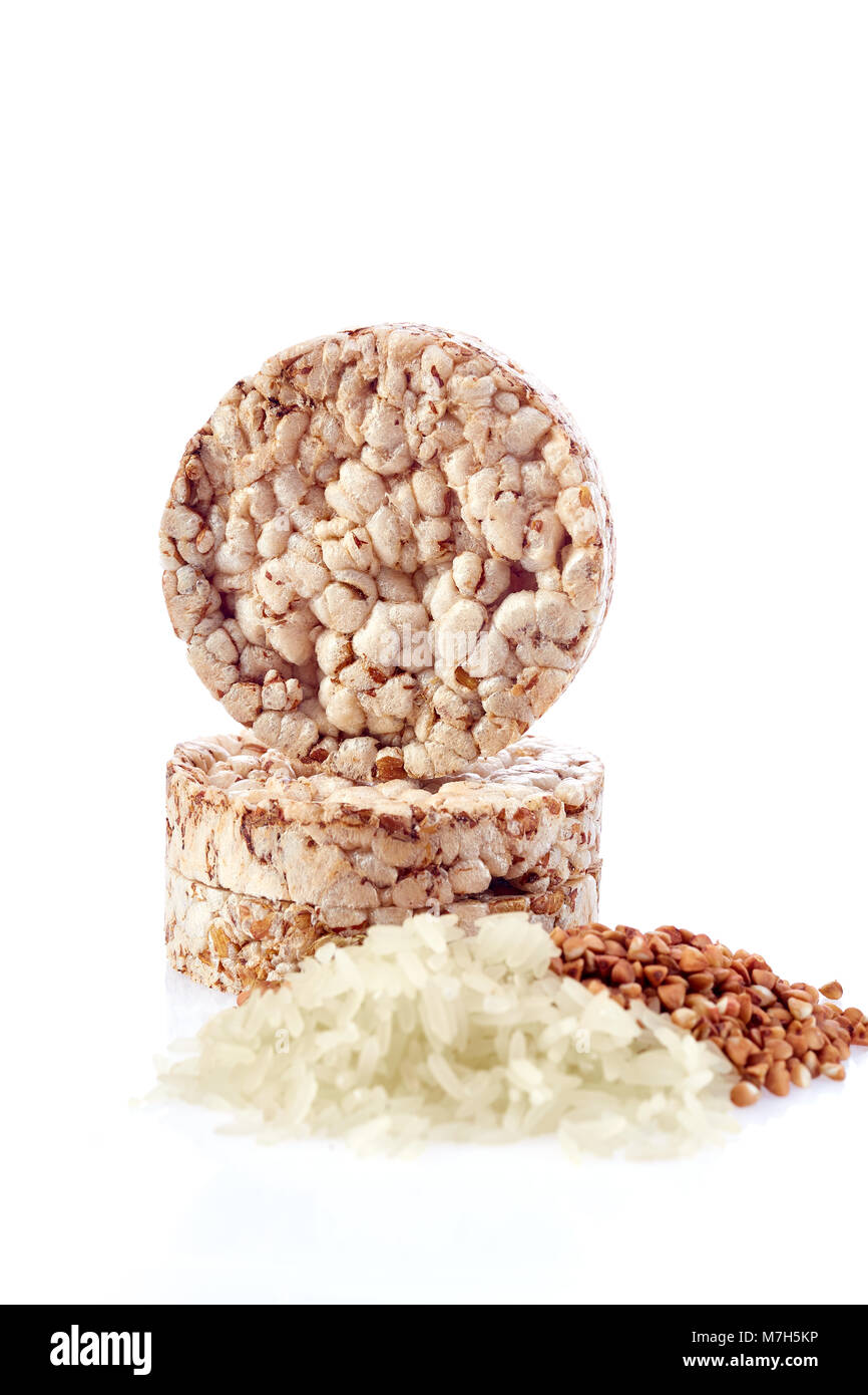 Diet rice cakes pile with buckwheat and rice grains isolated on white