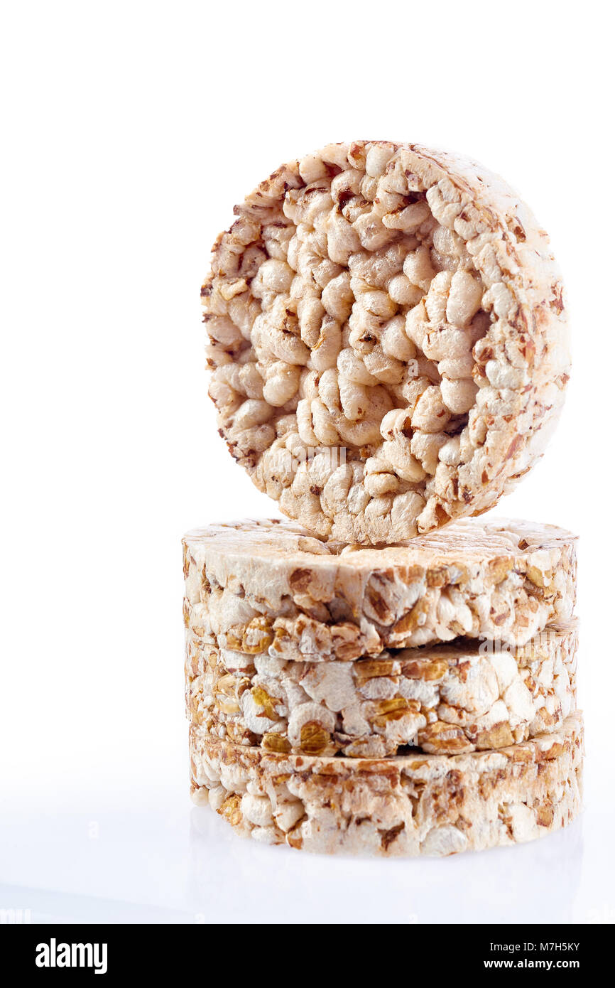 Diet rice cakes pile with buckwheat and rice grains isolated on white